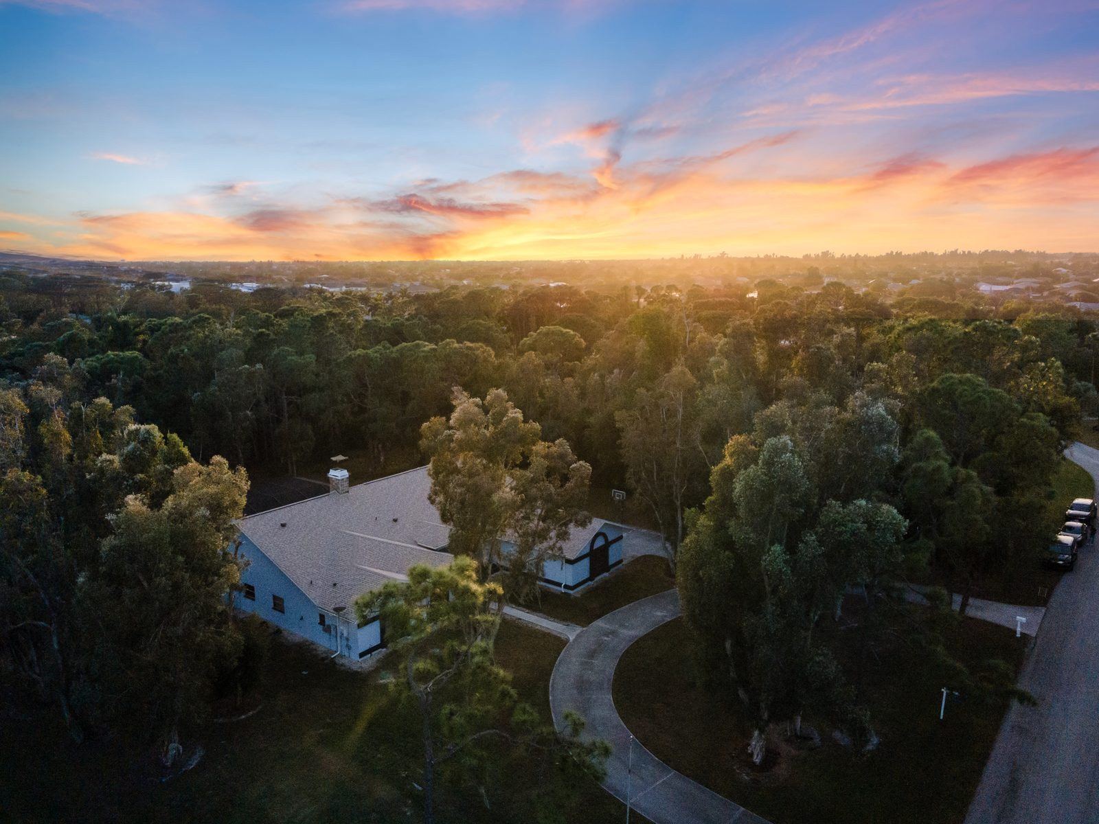 Aerial twilight photo of a home on a wooded cul-de-sac lot in Cape Coral, Florida