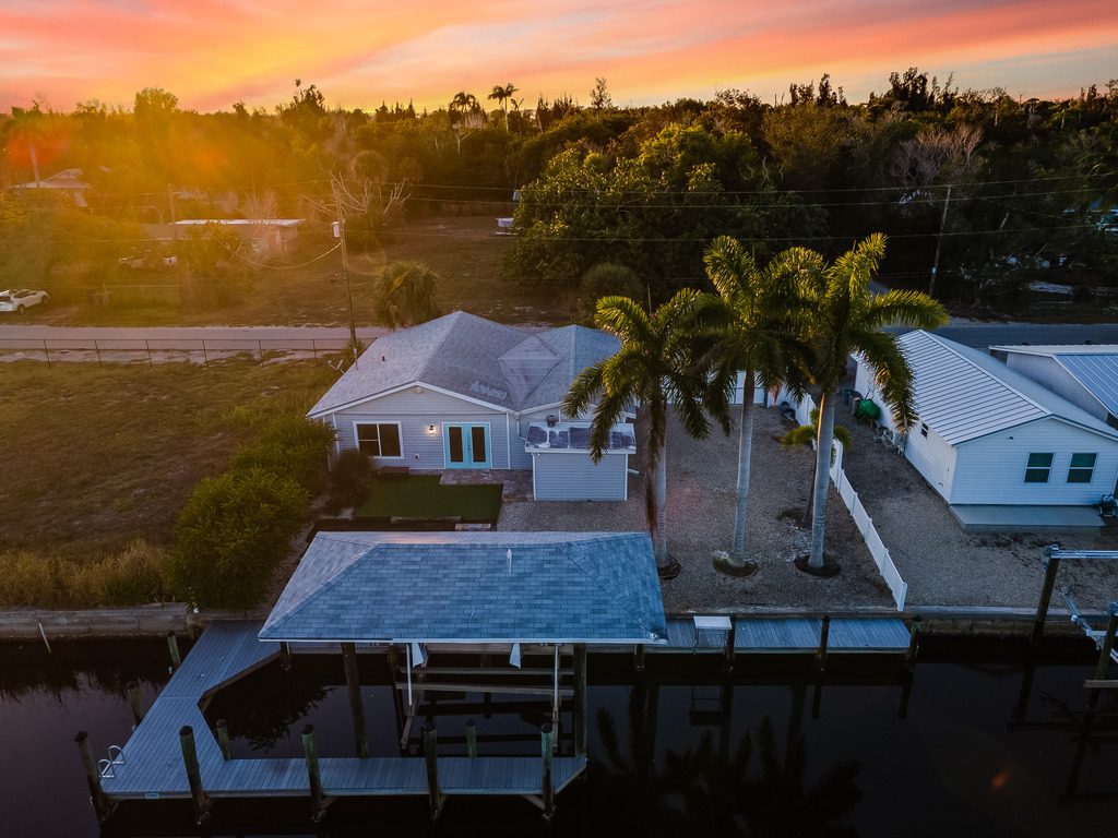 Aerial twilight photo of a canal-front home with dock in Matlacha, Florida